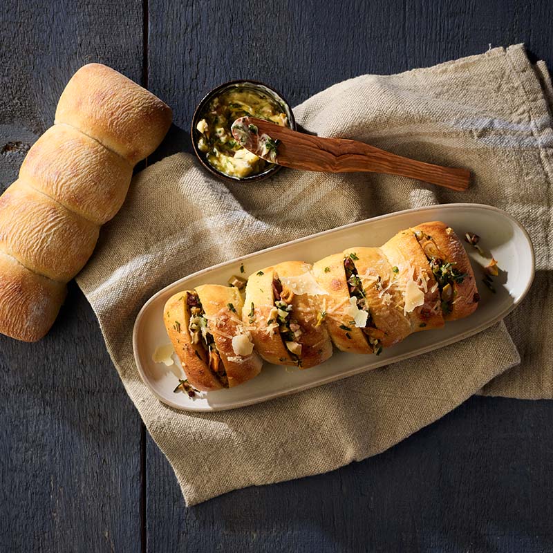 A rustic, tasty small loaf with a moist airy interior and a crisp golden crust, in a unique pull- apart shape. 8" x 3". Serve as a Fresh Herb and Olive-Stuffed Ciabatta Cluster!